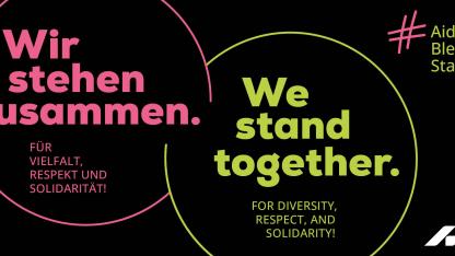Banner mit Slogan: &bdquo;Wir stehen zusammen. F&uuml;r Vielfalt, Respekt und Solidarit&auml;t! We stand together. For diversity, respect, and solidarity! #AidshilfeBleibtStabil, Logo Deutsche Aidshilfe